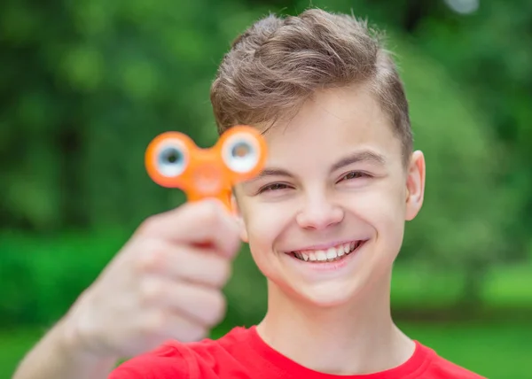 Teen boy with spinner toy in park — Stock Photo, Image