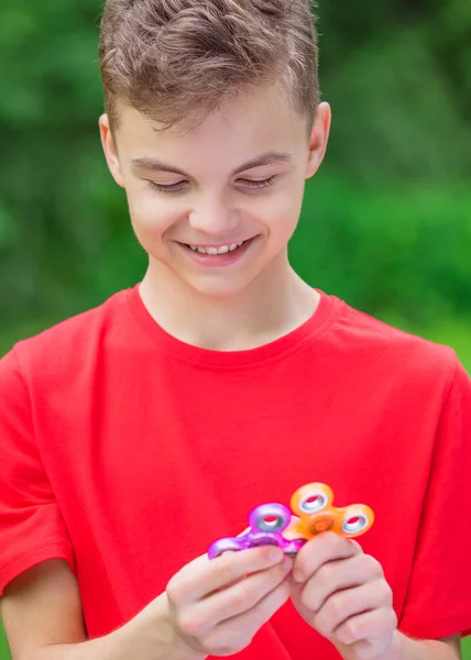 Teen pojke med spinner leksak i park — Stockfoto