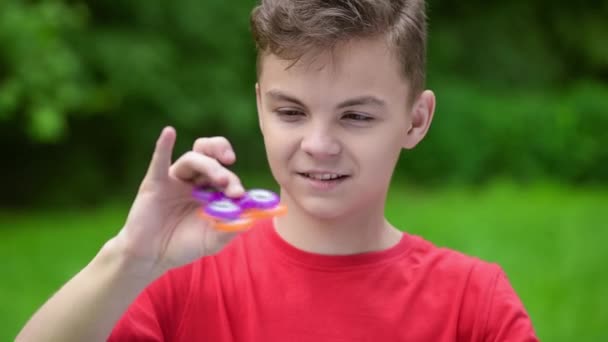 Tiener jongen met spinner in park — Stockvideo