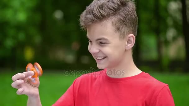 Teen boy with spinner in park — Stock Video