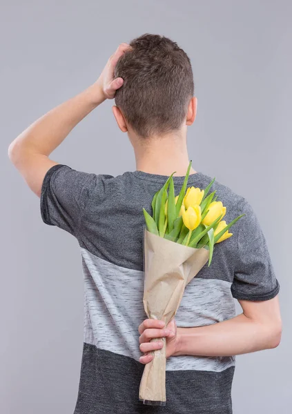 Adolescente chico con flores — Foto de Stock