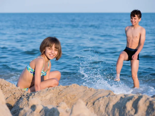 Broder och syster leker på stranden — Stockfoto