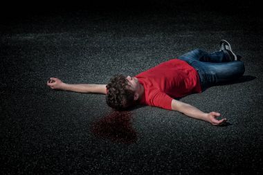 Dead teen boy on asphalt clipart