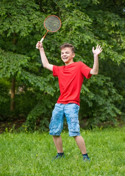 Tiener jongen spelen badminton in park — Stockfoto