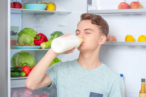 Menino com comida perto da geladeira — Fotografia de Stock