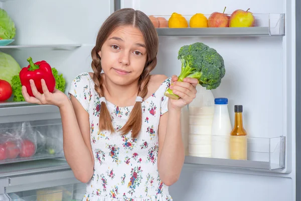 Κορίτσι με φαγητό κοντά στο ψυγείο — Φωτογραφία Αρχείου