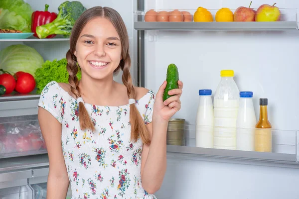 Menina com comida perto da geladeira — Fotografia de Stock