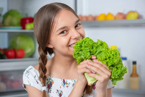 Chica con comida cerca de nevera — Foto de Stock