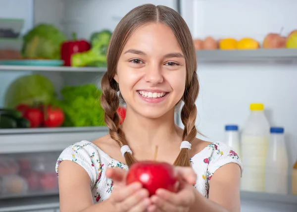 Flicka med mat nära kylskåp — Stockfoto