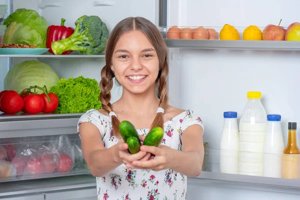 Chica con comida cerca de nevera — Foto de Stock