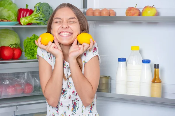 冷蔵庫の近くの食べ物を持つ女の子 — ストック写真