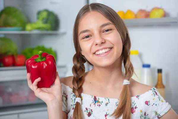 Chica con comida cerca de nevera — Foto de Stock