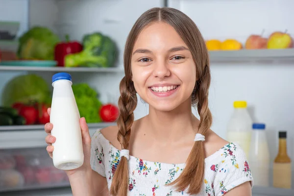 Chica con comida cerca de nevera — Foto de Stock