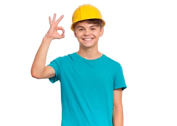面带微笑的少年男孩头戴黄色硬礼帽的画像 制作成 Gesture 白色背景孤立 戴着头盔的英俊的高加索少年看着相机 并给了好签名 — 图库照片