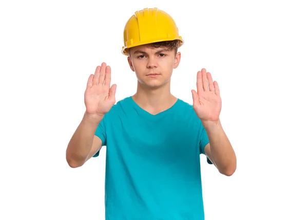 英俊的少年男孩戴着黄色的硬帽用手心做停车标志 严肃的儿童停止姿势和镜头的画像 用白色背景隔开 — 图库照片