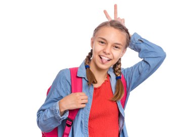 Sırt çantası ile Öğrenci genç kız kamera bakıyor ve baş parmakları ile boynuzları yapma. Sevimli gülümseyen kız öğrenci portresi beyaz arka plan üzerinde izole dil gösterir. Mutlu çocuk okula geri dön.