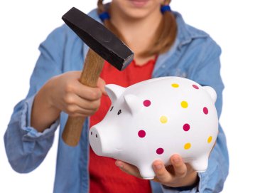 Piggy Bank ve Hammer 'ı tutan genç kızın ellerini kapatın. Beyaz arka planda izole edilmiş bir genç. Tasarruf konsepti. Komik çocuk kumbarasını kırmak üzere..