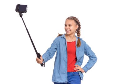 Sopa ile selfie yapan güzel mutlu genç kız portresi. Selfie çubuğuyla akıllı telefona poz veren genç, beyaz arka planda izole edilmiş. Sosyal ağ için cep telefonuyla selfie çeken çocuk.