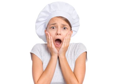 Güzel, şaşırmış ya da şok olmuş genç kız portresi beyaz arka planda izole edilmiş ellerle yüze dokunuyor. Şirin çocuk aşçı portresi, stüdyoda poz vermek, kameraya bakmak..