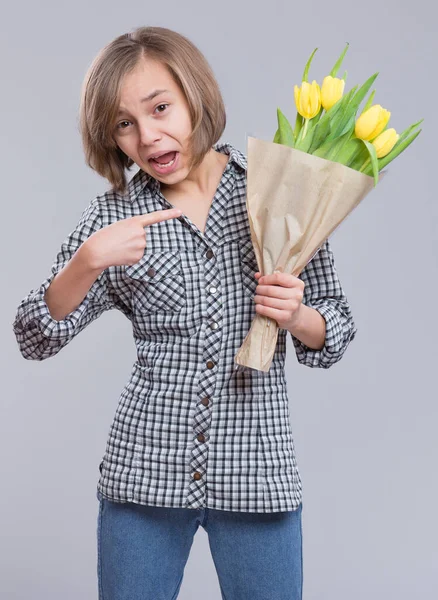 灰色の背景に花の束を持つ美しい女の子 贈り物として黄色のチューリップの花束を持つ驚きの子供 幸せな母親 誕生日やバレンタインデー — ストック写真