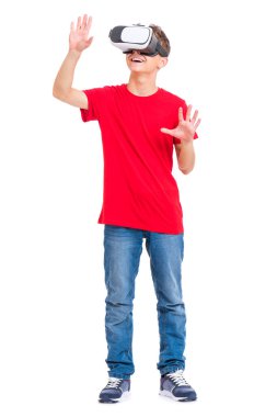 Full length portrait of young caucasian teen boy using virtual reality goggles. Funny teenager looking in VR glasses. Handsome child experiencing 3D gadget technology, isolated on white background. clipart