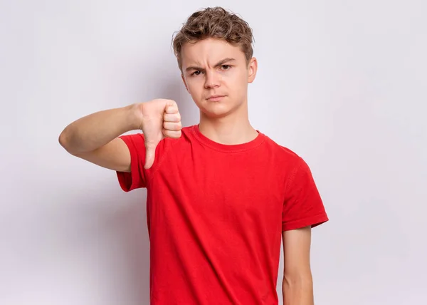 Egy Tinédzser Fiú Arcképe Amint Hüvelykujját Lefelé Mutogatja Negatív Arckifejezéssel — Stock Fotó
