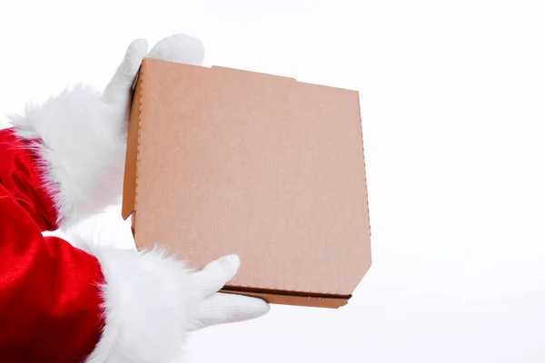 クリスマスピザとファーストフードの配達。サンタクロースの手は白い背景にピザボックスを保持します。テキストやロゴのためにモックアップします。コピースペース. — ストック写真