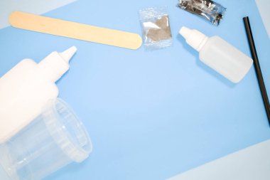 Evde nasıl sümük yapılacağını. Çocuk sanat projesi. Diy kavramı. Çocuk elleri mavi arka planda sümüklü oyuncak yapıyor. Adım adım fotoğraf talimatları. Adım 1. Kopyalama alanı