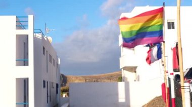 Gran Canaria İspanya 'da Avrupa devletlerinin bayraklarının yanında Gay Gökkuşağı Bayrağı sallamak, Lgbt topluluğunun gurur sembolü. Beyaz evler ve arka planda dağlar. İnsan Hakları, Eşitlik.