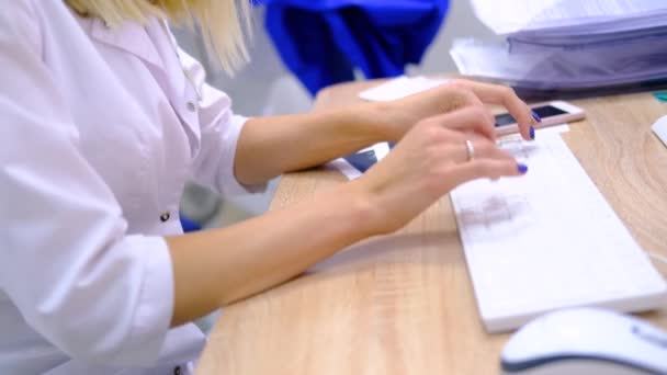 Mujer cirujano médico en uniformes blancos en el teclado de la computadora los resultados de diagnóstico y examen. Las manos cerca. Tecnologías médicas modernas. Salud y medicina. Imágenes de 4k — Vídeos de Stock