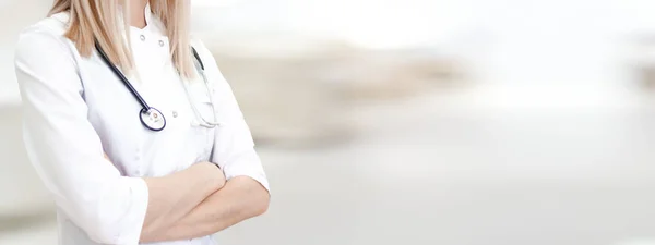 Medical wide banner with copyspace for text. Cropped caucasian woman doctor in white uniform. Blurred clinic on background. Healthcare, pharmacology concept.