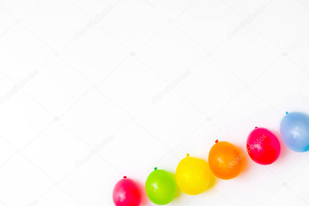 Colorful balloons on white wall or table top view. Festive or party background. Flat lay style. Copyspace for text. Birthday greeting card.