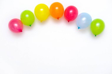 Beyaz duvarda renkli balonlar ya da masa üstü manzaralı. Şenlik ya da parti geçmişi. Düz yatış stili. Metin için kopyalanma alanı. Doğum günü tebrik kartı.