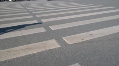 Summer City caddesinde kesişen yol. Bisikletçiler, arabalar, yoldan geçen insanların bacakları. Tanınmayacak kadar kalabalık yaklaşıyor. 4k. 