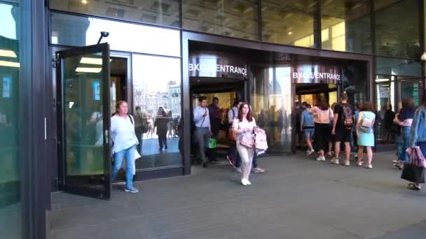 Mulțimea de oameni multietnici părăsesc clădirea centrului comercial sau a aeroportului prin uși de sticlă. Turiști cu valize și saci. Picioarele se apropie. Ziua de vară a oraşului. St.Petersburg 18aug2019 — Videoclip de stoc