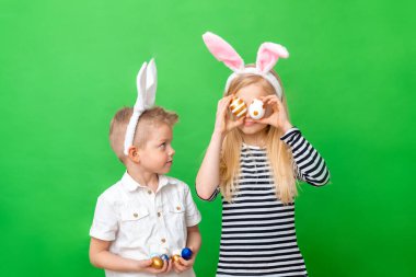 Neşeli çılgın çocuk ve tavşan kulaklı kız yeşil stüdyo geçmişinde kafa kafaya. Paskalya 'da gözlere yumurta boyarlar. Paskalya ve tatil kavramı