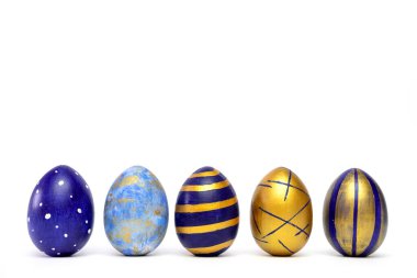 Beş Paskalya yumurtası. Beyaz masanın üzerinde klasik mavi, beyaz ve altın renkli. Mesaj için fotokopi alanı olan mutlu Paskalyalar. Asgari biçim