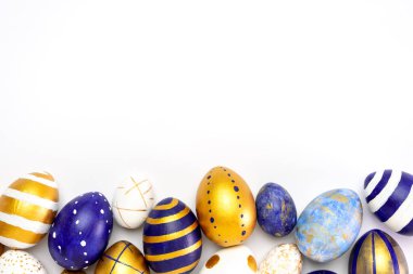 Mutlu Paskalyalar. Paskalya yumurtalarından yapılmış metin çerçevesi modaya uygun renkli klasik mavi, beyaz ve beyaz üzerine altın rengi. Asgari biçim, üst görünüm, düz görünüm, kopyalama alanı.