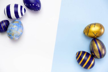 Mutlu Paskalyalar. Paskalya yumurtalarından yapılmış metin çerçevesi. Renkli klasik mavi, beyaz ve mavi üzerine altın rengi. Asgari biçim, üst görünüm, düz görünüm, kopyalama alanı.
