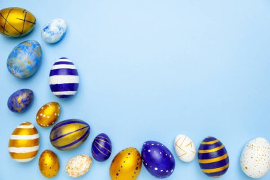 Mutlu Paskalyalar. Paskalya yumurtalarından yapılmış metin çerçevesi. Renkli klasik mavi, beyaz ve mavi üzerine altın rengi. Asgari biçim, üst görünüm, düz görünüm, kopyalama alanı.