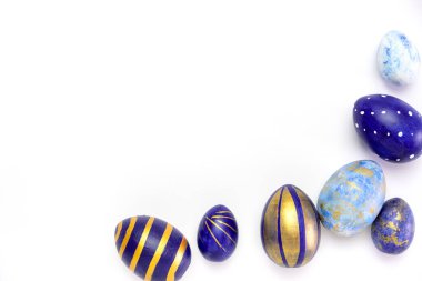 Mutlu Paskalyalar. Paskalya yumurtalarından yapılmış metin çerçevesi modaya uygun renkli klasik mavi, beyaz ve beyaz üzerine altın rengi. Asgari biçim, üst görünüm, düz görünüm, kopyalama alanı.