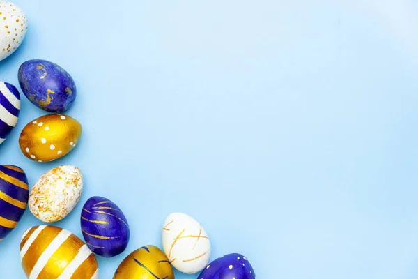 复活节快乐用复活节彩蛋制成的纯蓝色、白色和金色蓝色相间的文本框架。最小样式、顶视图、平铺、复制空间. — 图库照片