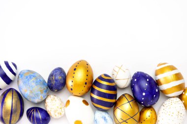 Mutlu Paskalyalar. Paskalya yumurtalarından yapılmış metin çerçevesi modaya uygun renkli klasik mavi, beyaz ve beyaz üzerine altın rengi. Asgari biçim, üst görünüm, düz görünüm, kopyalama alanı.