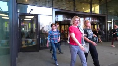 Kalabalık çok ırklı insanlar alışveriş merkezi veya havaalanı binasını cam kapılardan terk ediyorlar. Çantalı ve bavullu turistler. Bacaklar yakın. Şehir yaz günü. St. Petersburg 18Ağustos 2019