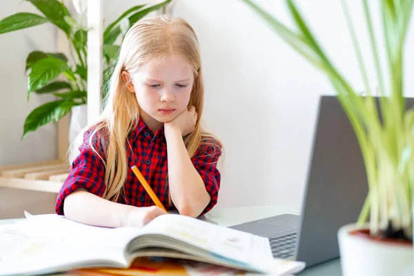 Distance learning online education. Schoolgirl studying at home with digital tablet and doing school homework. Training books and notebooks on table. — Stock Photo, Image