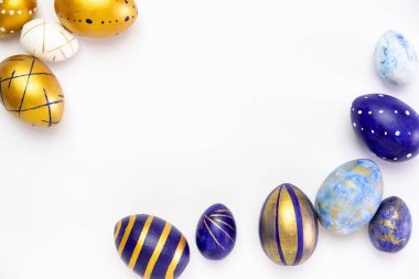Mutlu Paskalyalar. Paskalya yumurtalarından yapılmış metin çerçevesi modaya uygun renkli klasik mavi, beyaz ve beyaz üzerine altın rengi. Asgari biçim, üst görünüm, düz görünüm, kopyalama alanı.