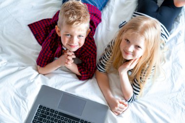 Uzaktan öğrenme çevrimiçi eğitim. Okul çocuğu ve kızın dijital tablet dizüstü bilgisayarla evde ders çalışmasını ve okul ödevlerini yapmasını izliyoruz. Eğitim kitaplarıyla yatakta oturmak..
