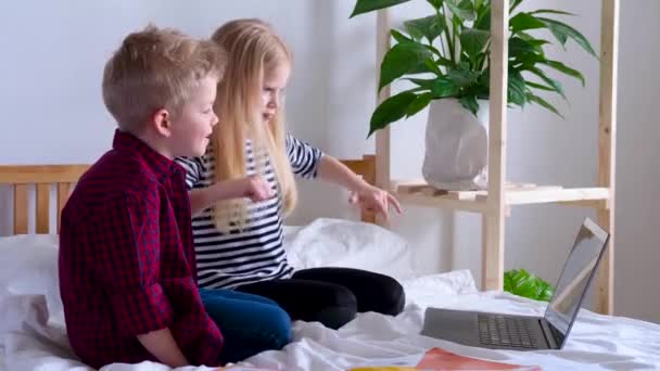 Niños divirtiéndose en casa. Colegial y chica bailando, saltando a la cama. Cuarentena contra el Coronavirus, autoaislamiento, vacaciones, educación en línea — Vídeo de stock