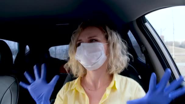 4k Lockige blonde Fahrerin in gelber Sommerkleidung und mit medizinischer Maske und Schutzhandschuhen, die vor der Fahrt im Auto tanzen. Frau gegen Erkältung. Bleiben Sie unter Quarantäne. — Stockvideo