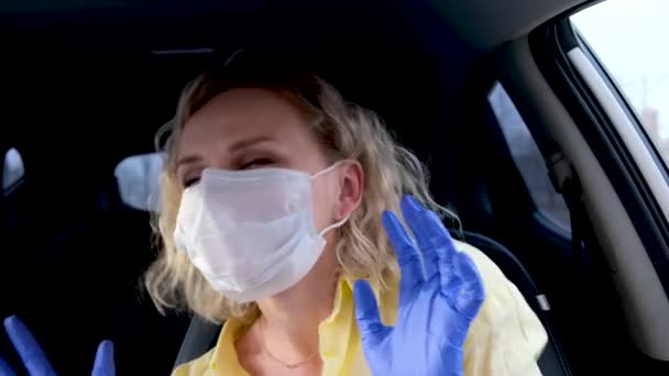 4k Chica rubia rizada conductora en máscara médica y guantes protectores bailando en coche antes de conducir. Mujer en amarillo desgaste de verano contra el resfriado gripe común. Quédate en casa en cuarentena . — Vídeo de stock